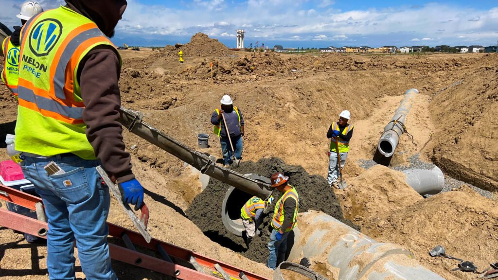 Nelson Pipeline employees pouring cement into a scaffold