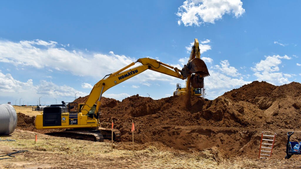 Excavators digging trenches on job site