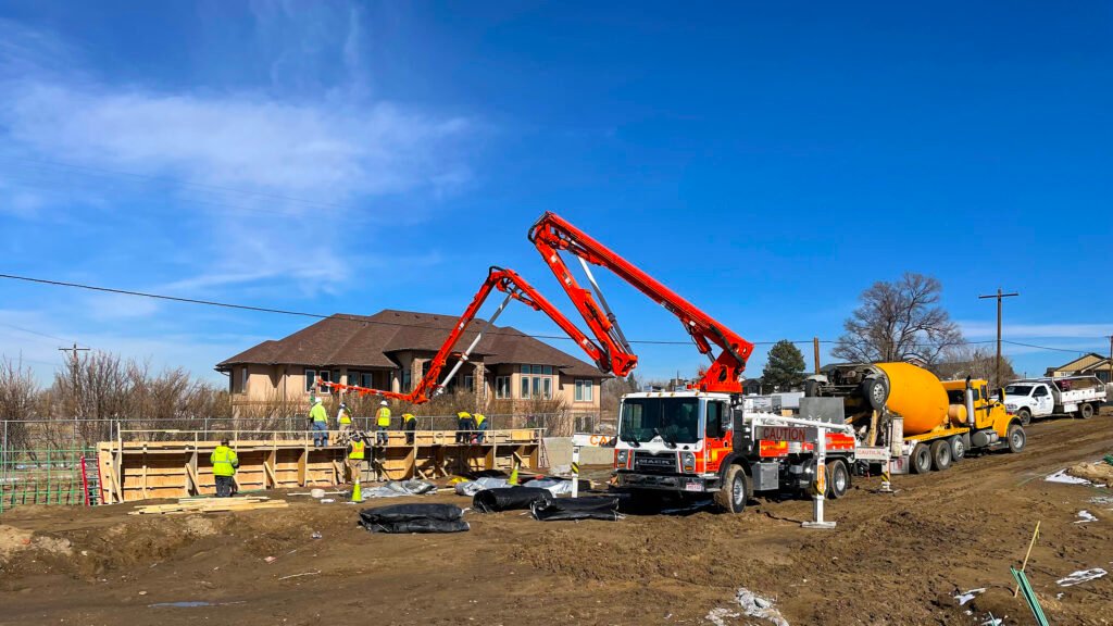 Truck crane distributing cement into scaffolding