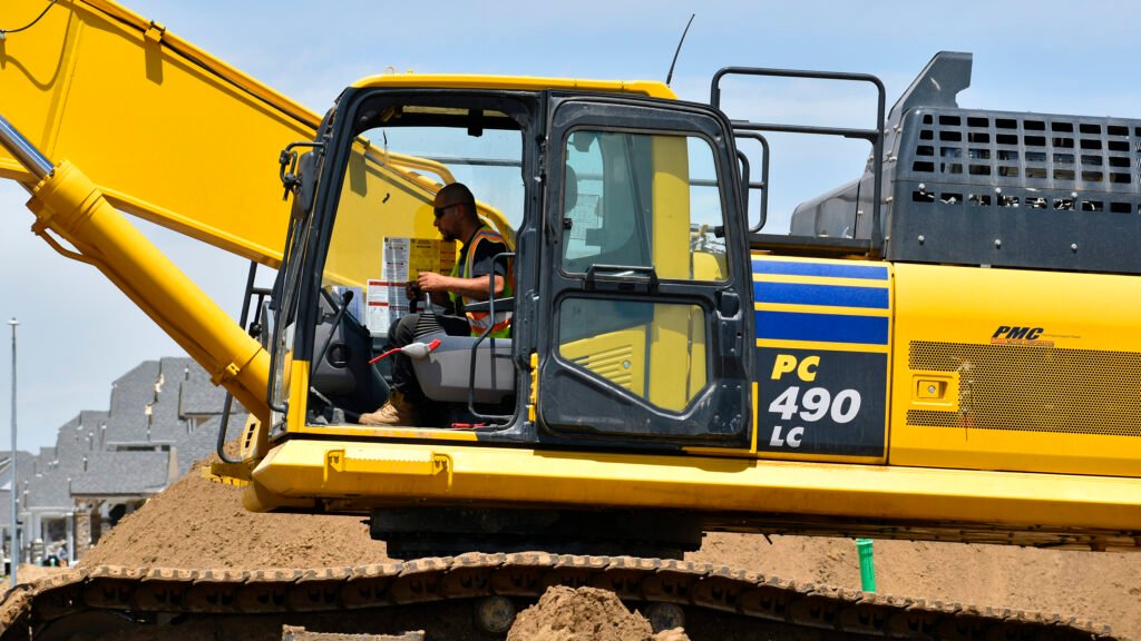 Nelson Pipeline employee operating an excavator on a job site